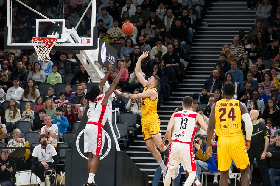 Dramatic moment in a basketball game with players and an engaged crowd.