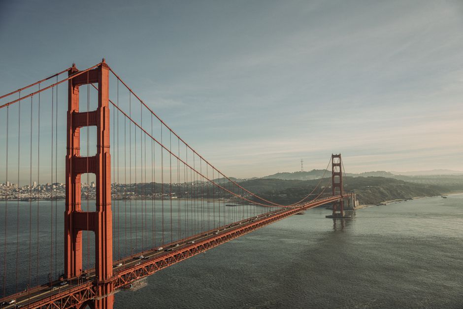 A stunning view of the Golden Gate Bridge with the San Francisco skyline in the backdrop at sunset.